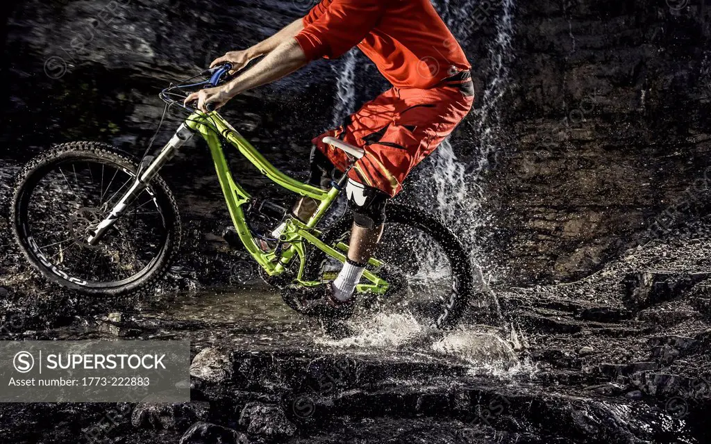Cropped image of mountain bike riding through water
