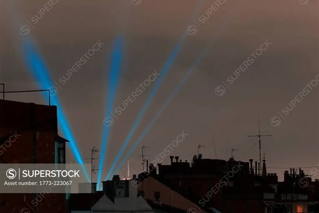 Rooftops and blue laser lights at sunset, Barcelona, Spain