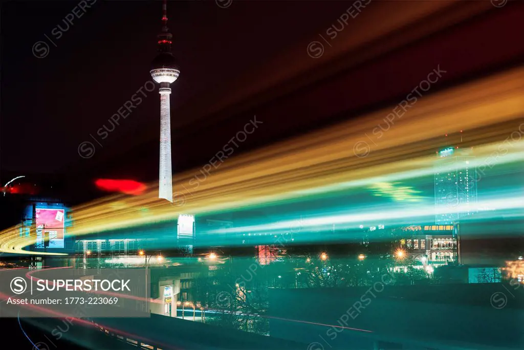 Night time view of moving train and television tower, Berlin, Germany