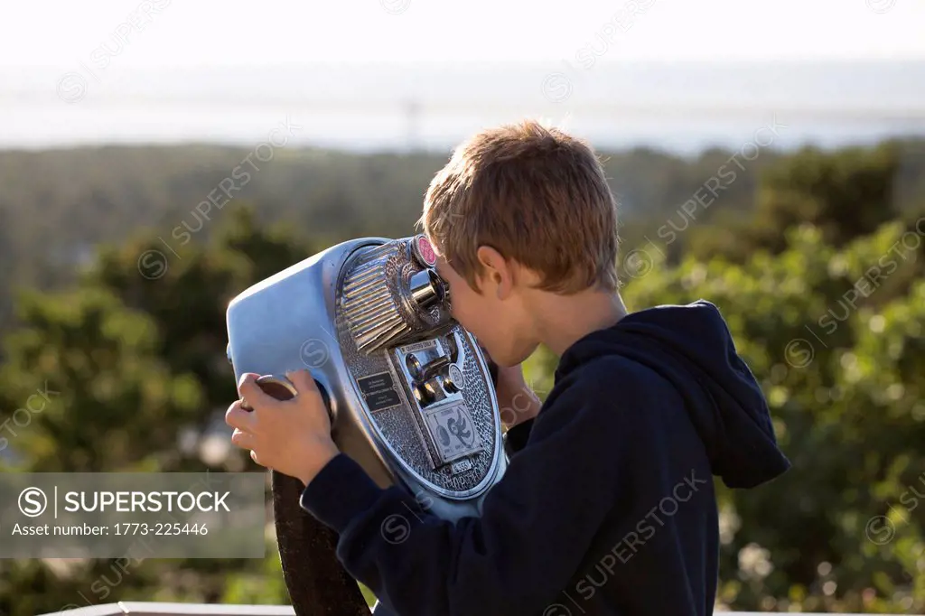 Boy using coin operated binoculars