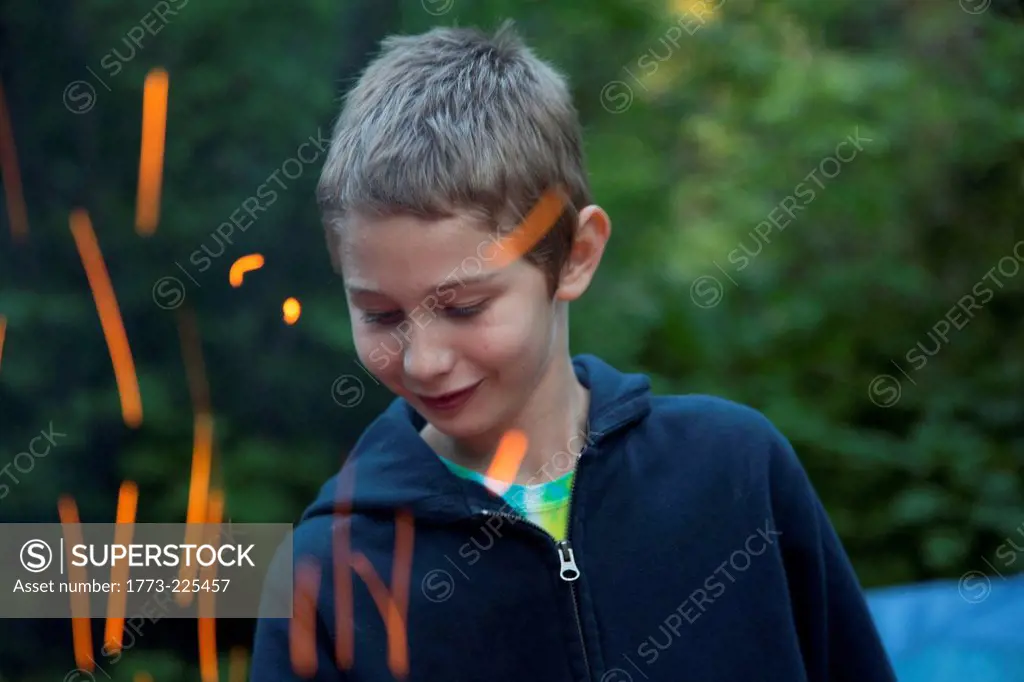 Boy with sparks from campfire