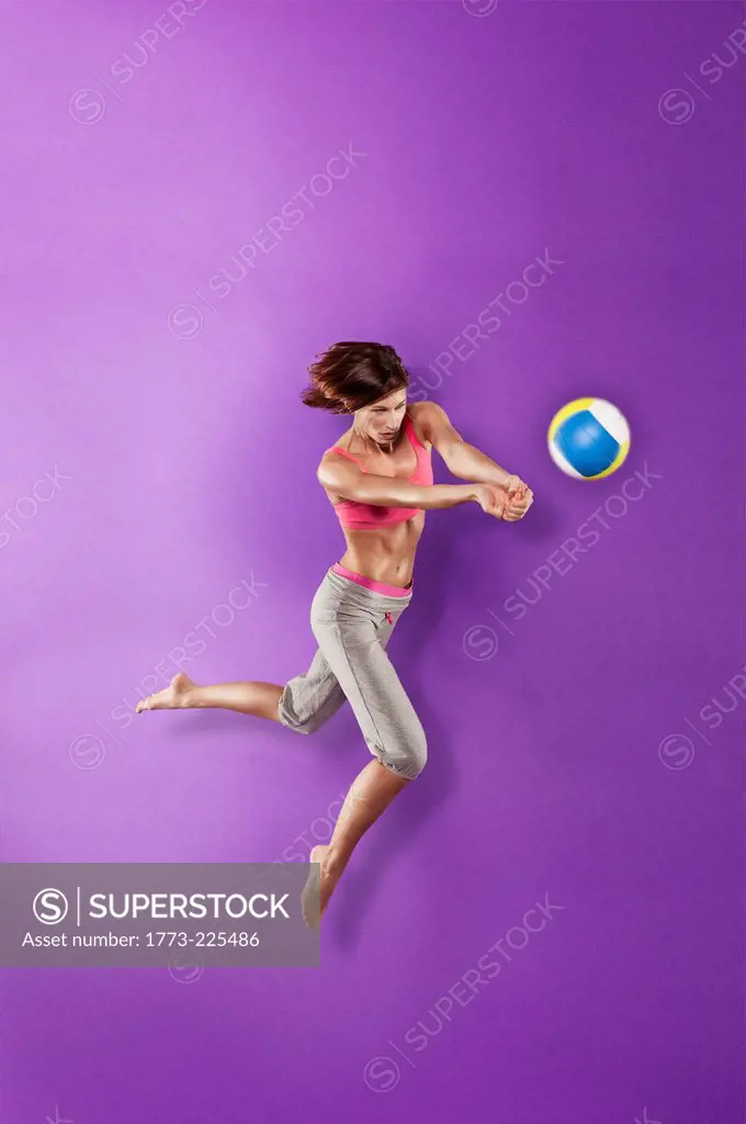 Volleyball player hitting ball