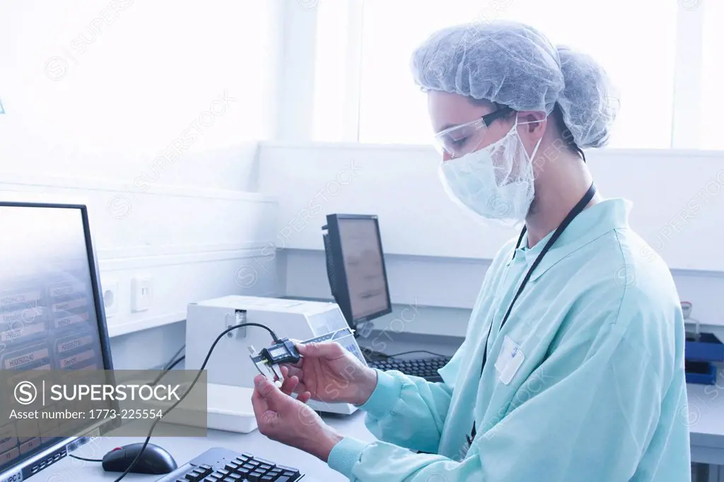 Laboratory technician checking and adjusting equipment reading