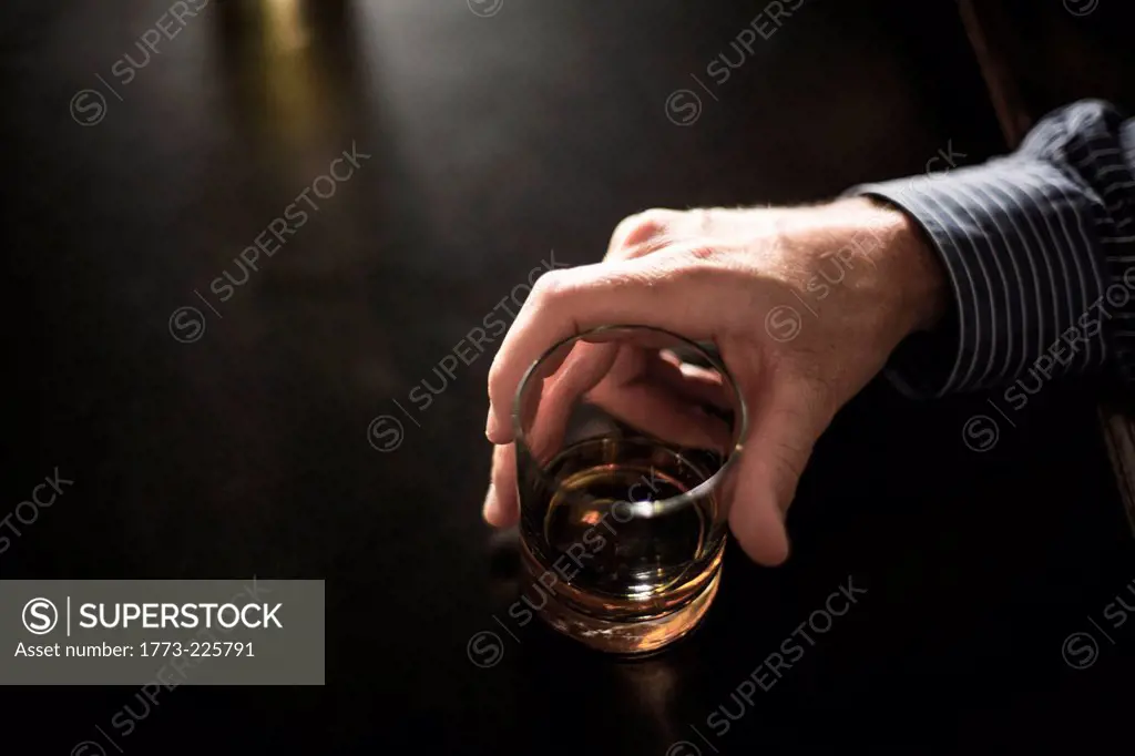 Close up of solitary man with drink in bar