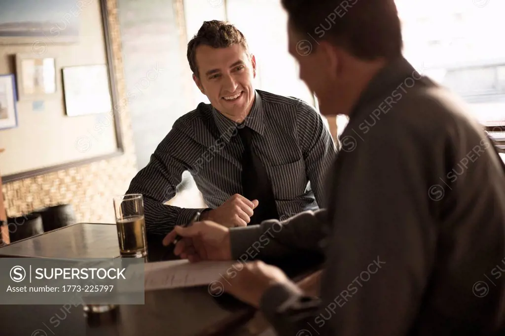 Business partners signing contract in a wine bar