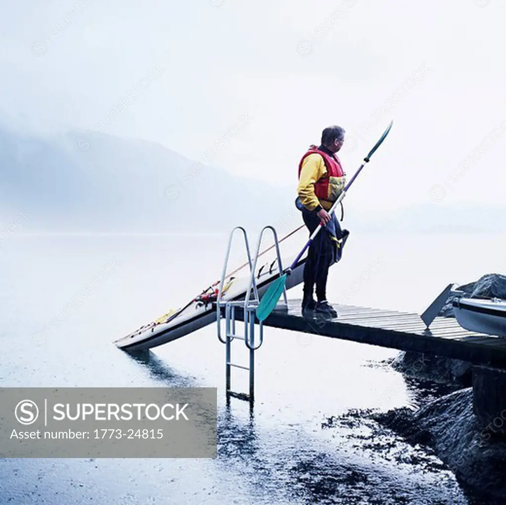 Man pulling kayak onto dock