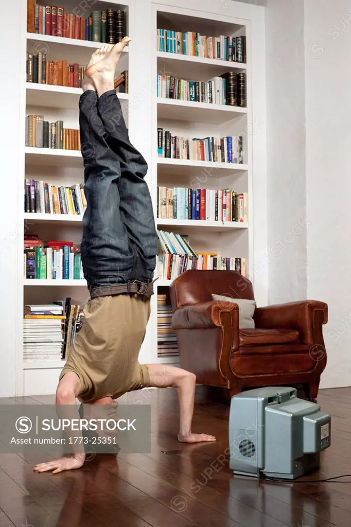 man standing on head with tv