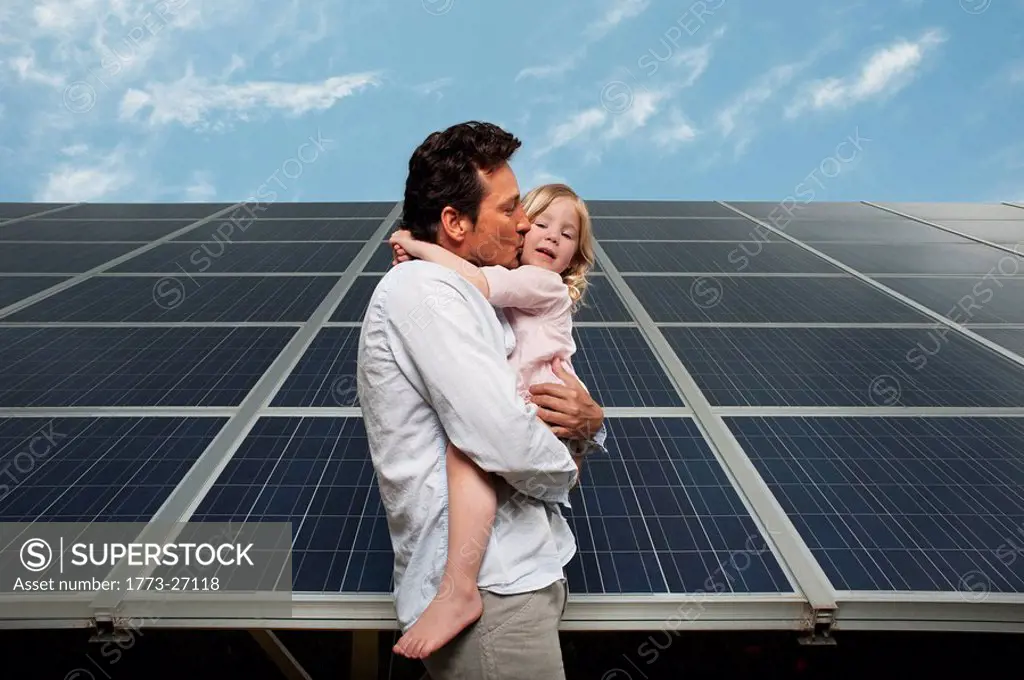 Man and daughter in front of solar panel