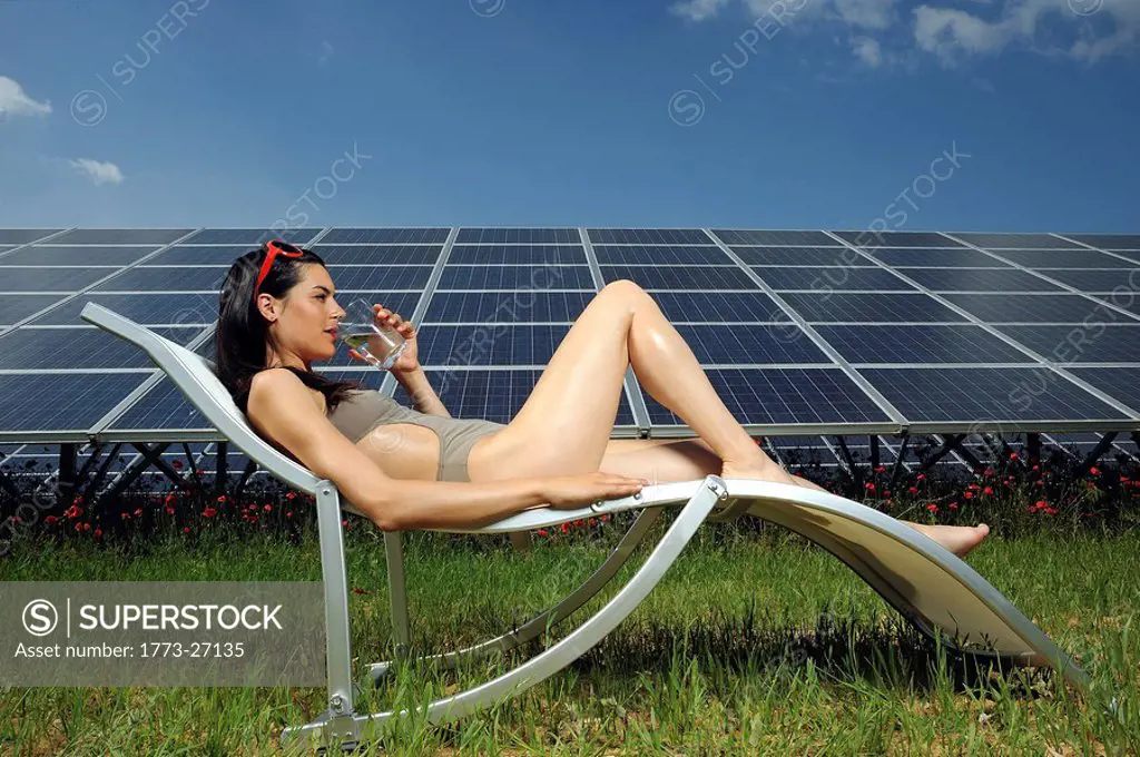 woman sunbathing in front of solar panel