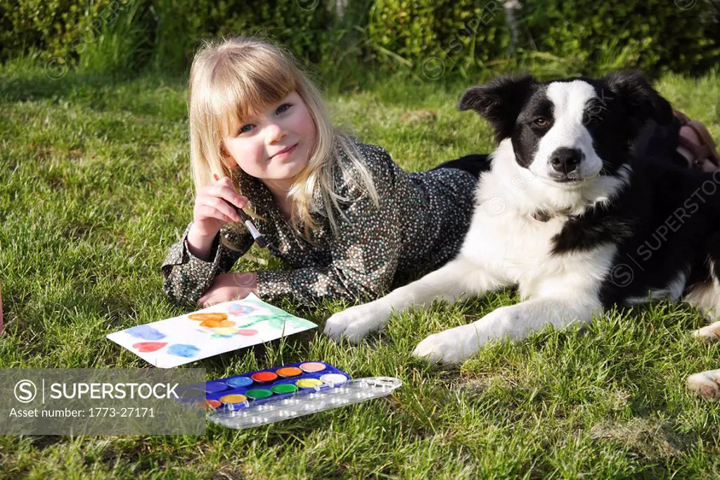 Child paint with her dog in the garden