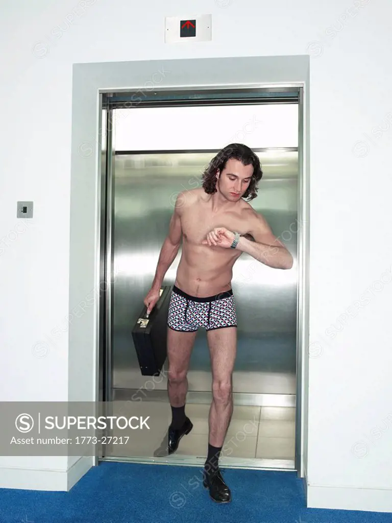 man in underwear walking out of a lift
