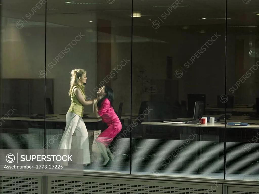two women fighting in an office