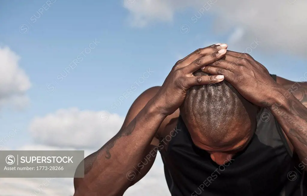male athlete holding head in despair
