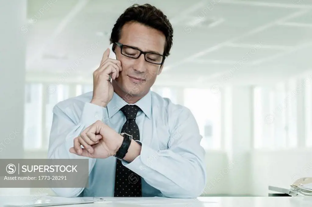 Businessman on phone looking at watch