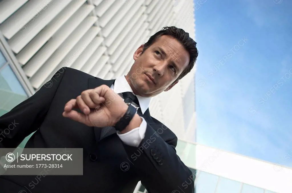 Businessman keeping time with watch