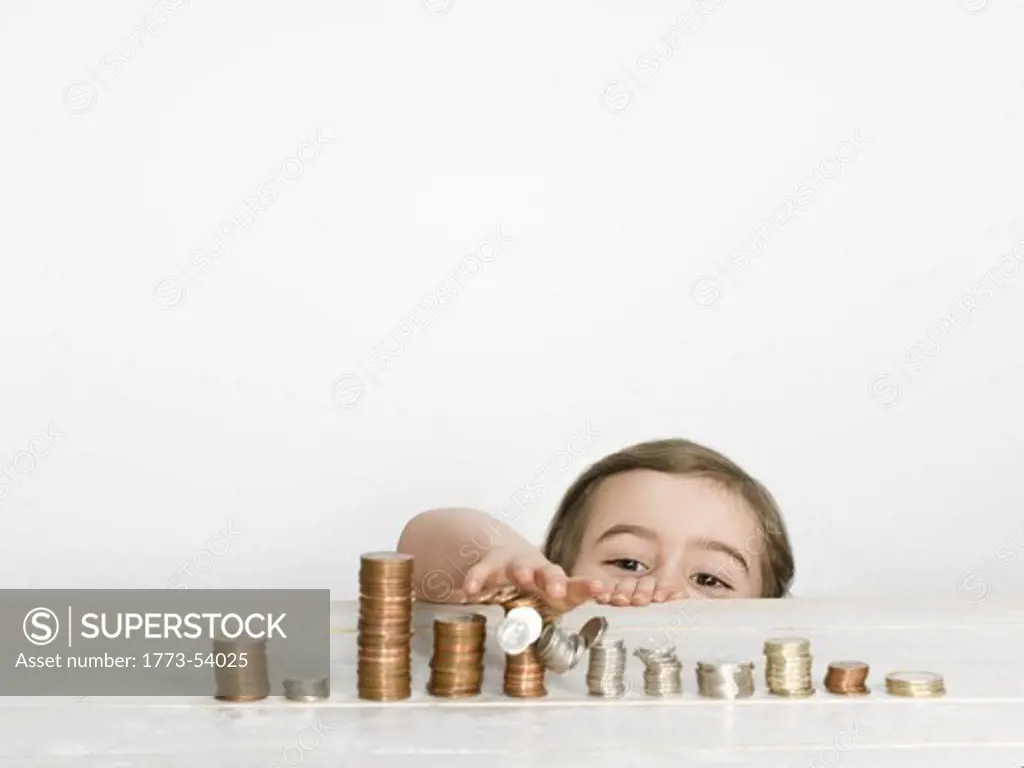 Girl stacking coins on counter