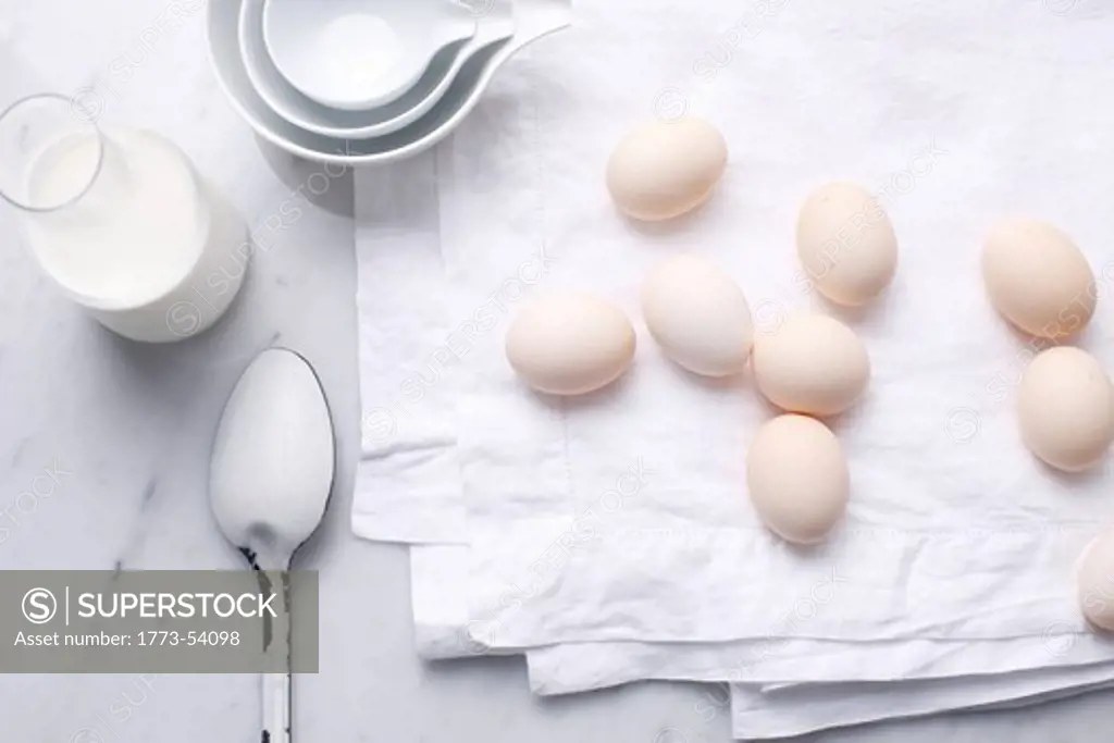 Eggs, milk and spoon on table