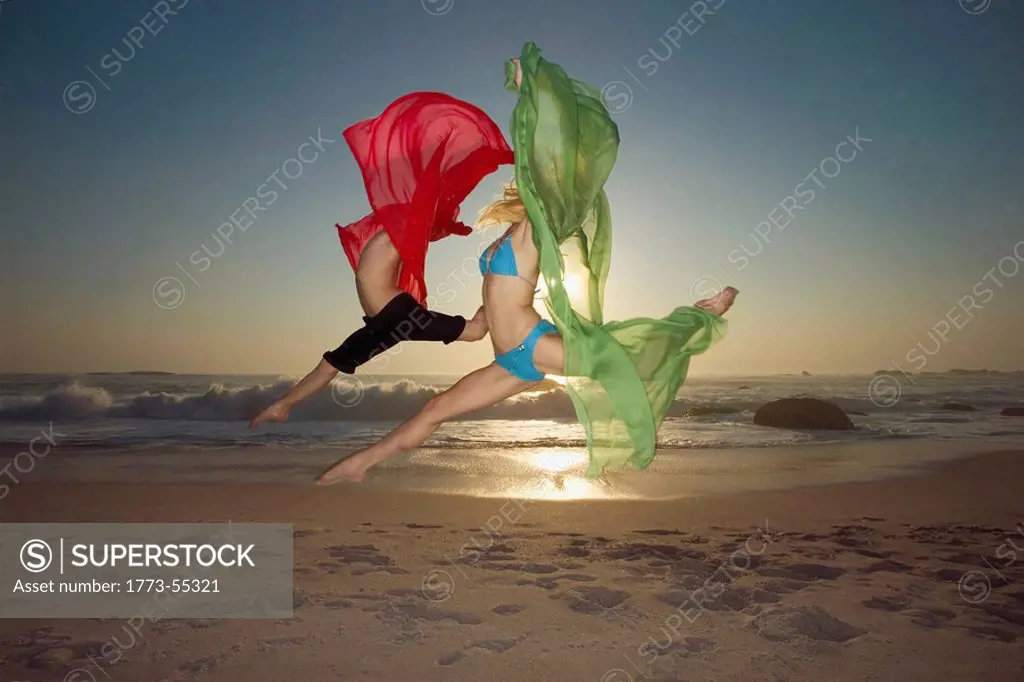 Dancers leaping on a beach