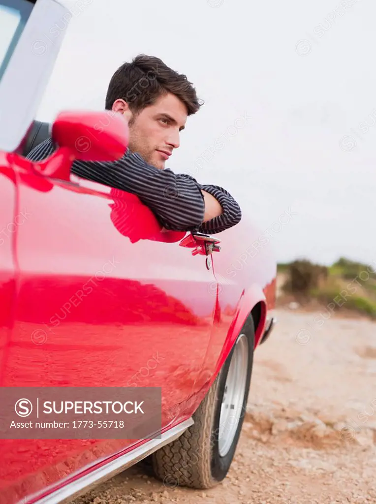 man leaning out of an open_topped car