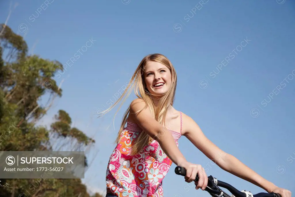 Blonde woman smiling riding mountain bike