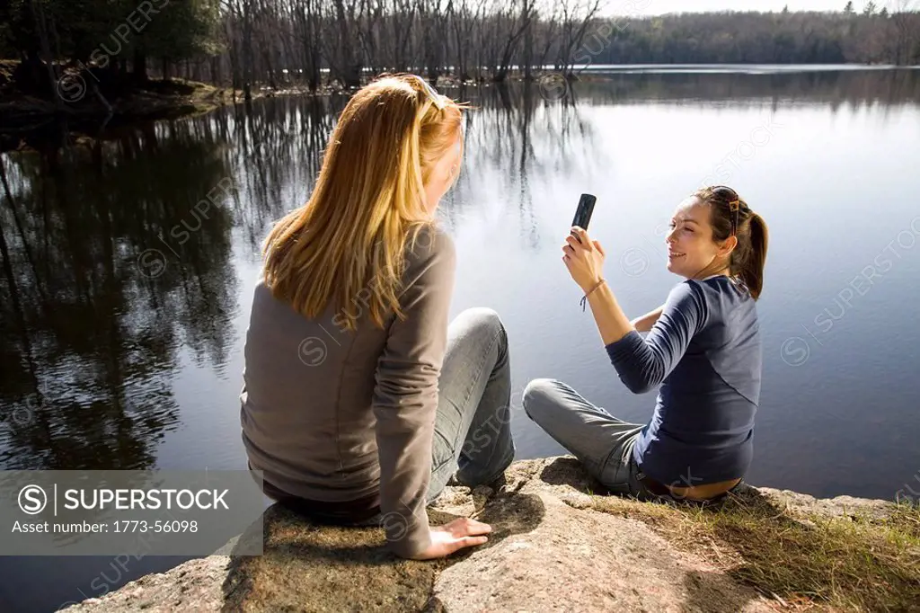 Two women taking picture with phone