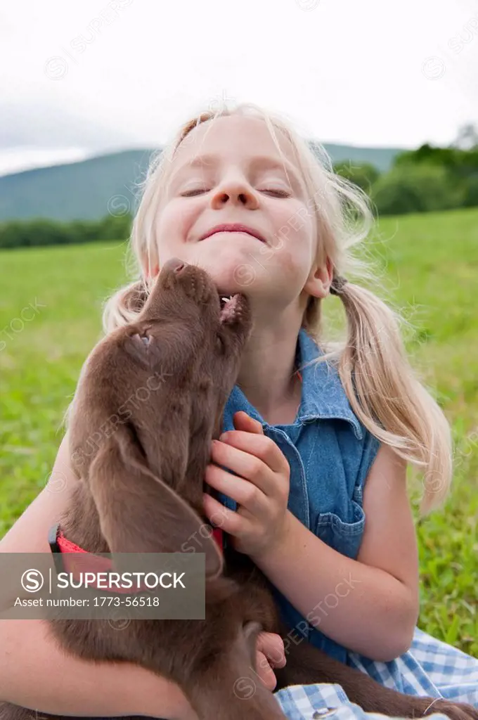 Young girl hugging her puppy