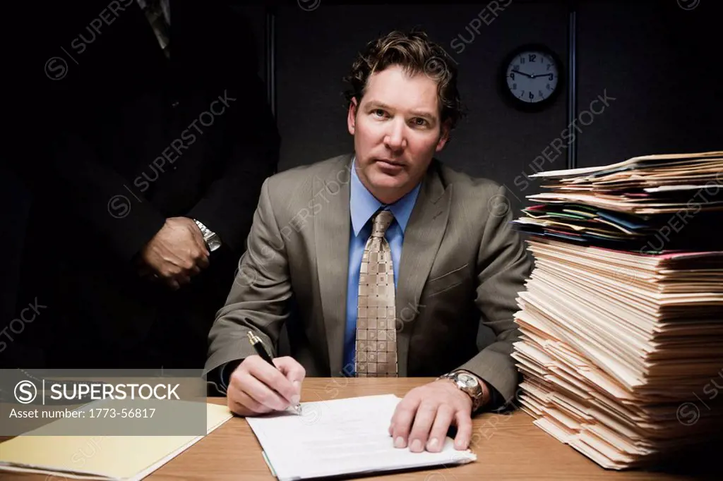 Man doing paperwork with man behind him