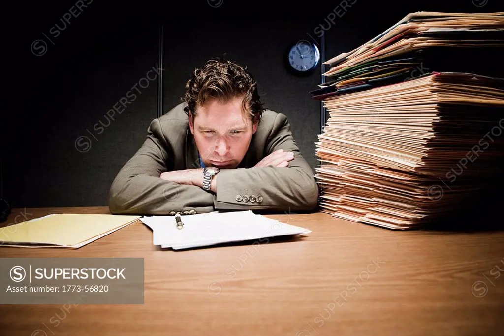 Stressed man with head down on desk