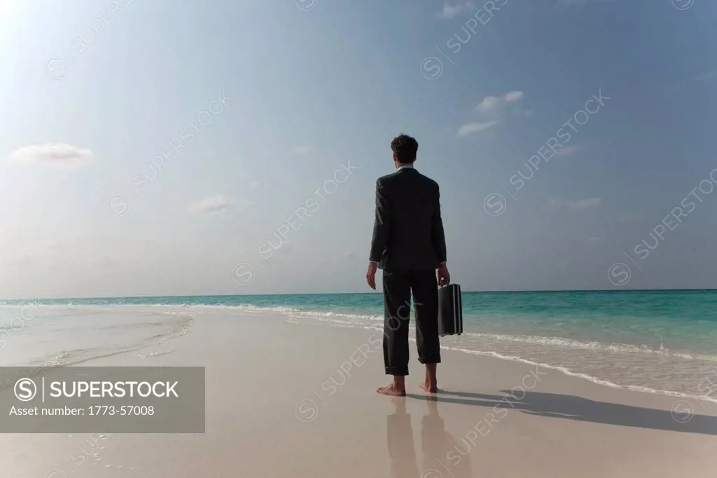Businessman walking on tropical beach