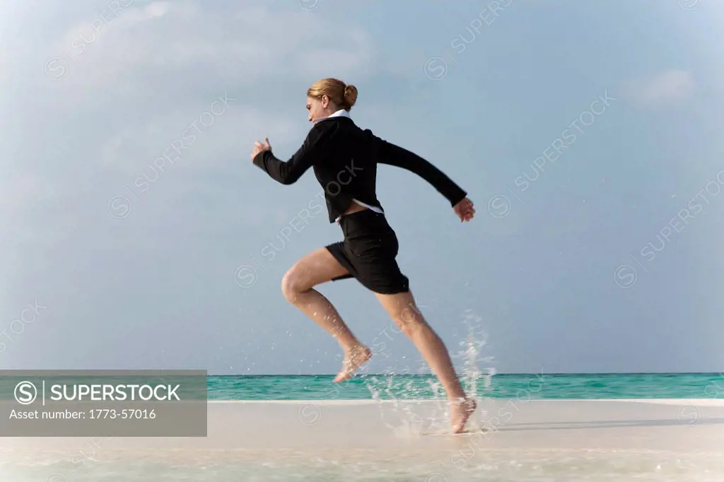 Businesswoman running on tropical beach