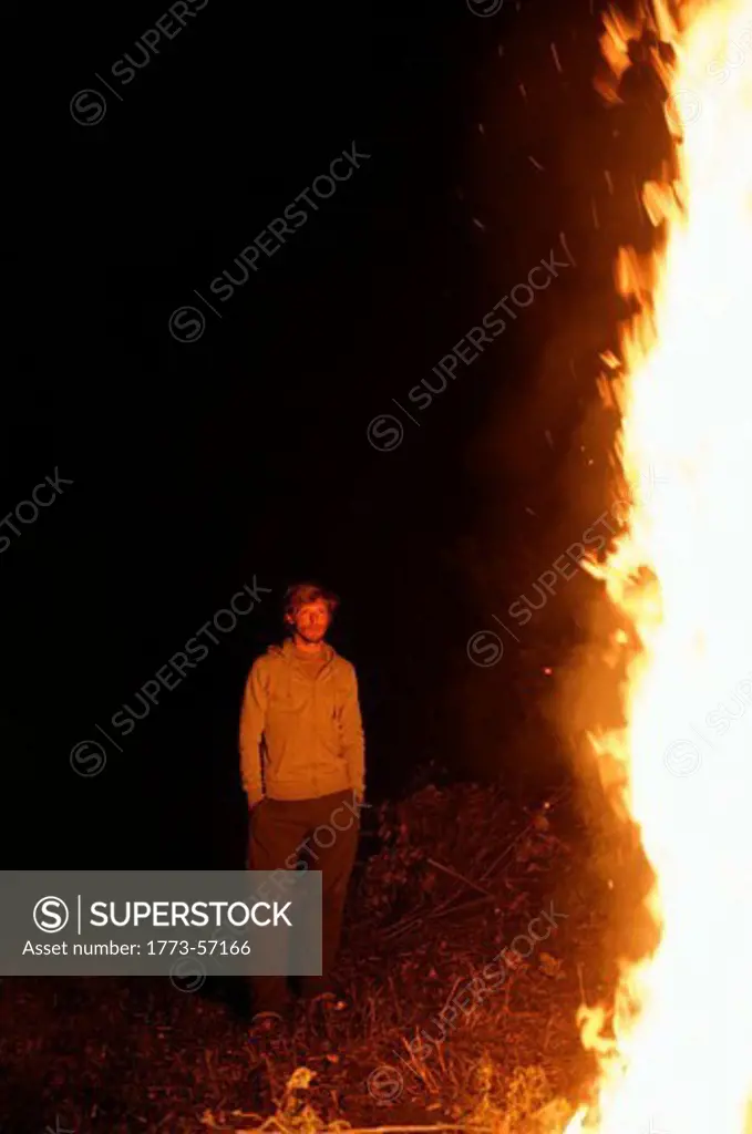 Man admiring campfire at night