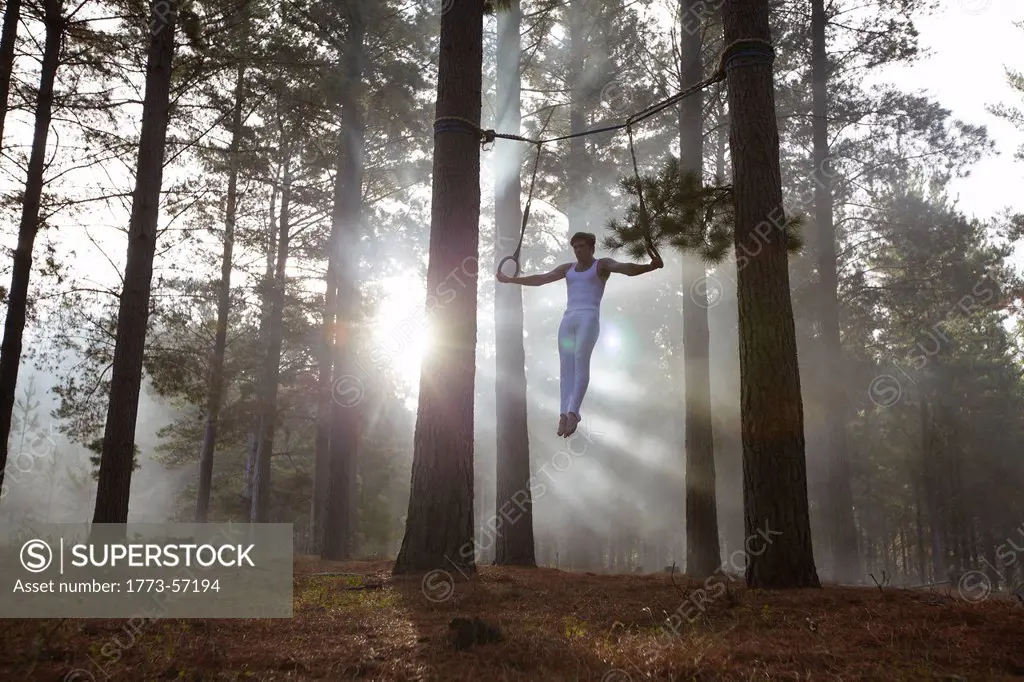 Gymnast using rings in forest
