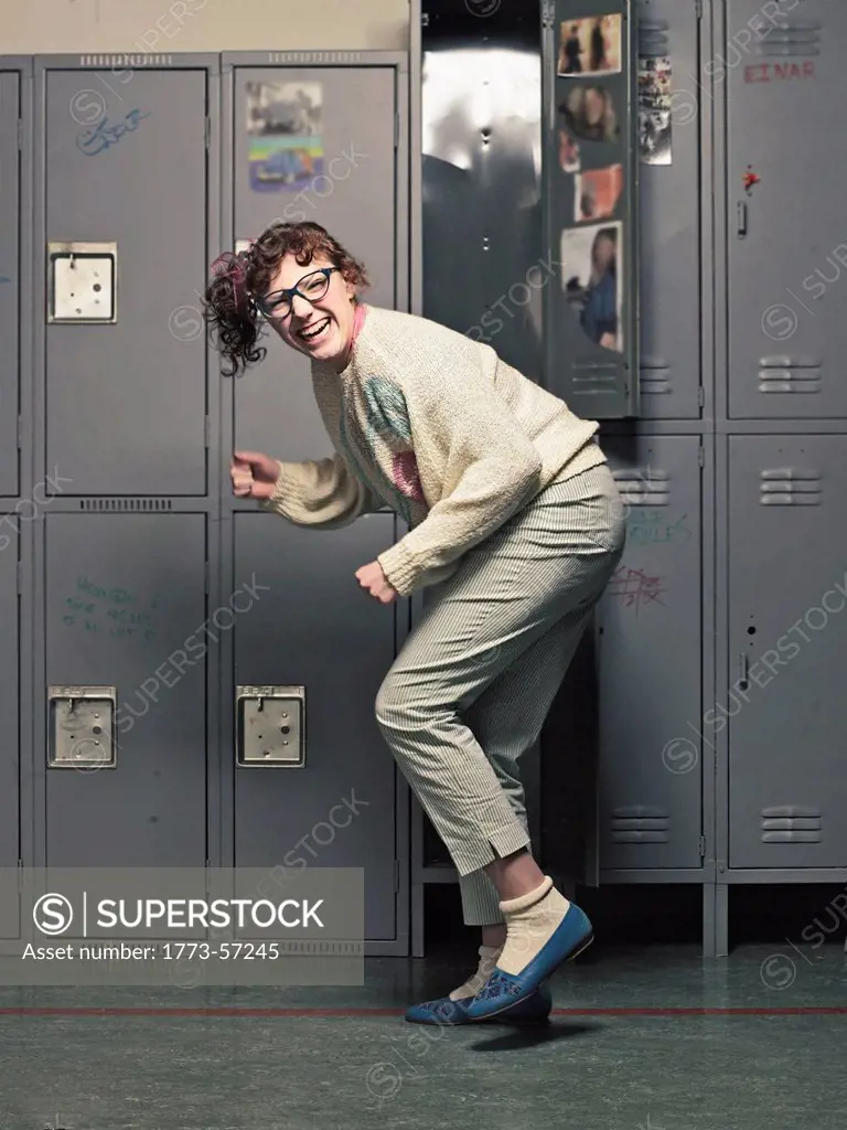 Woman in glasses dancing at her locker