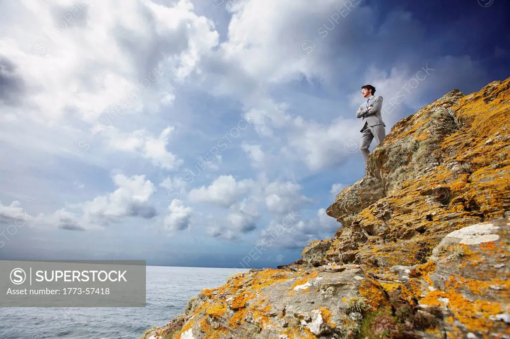 Businessman standing on cliff edge