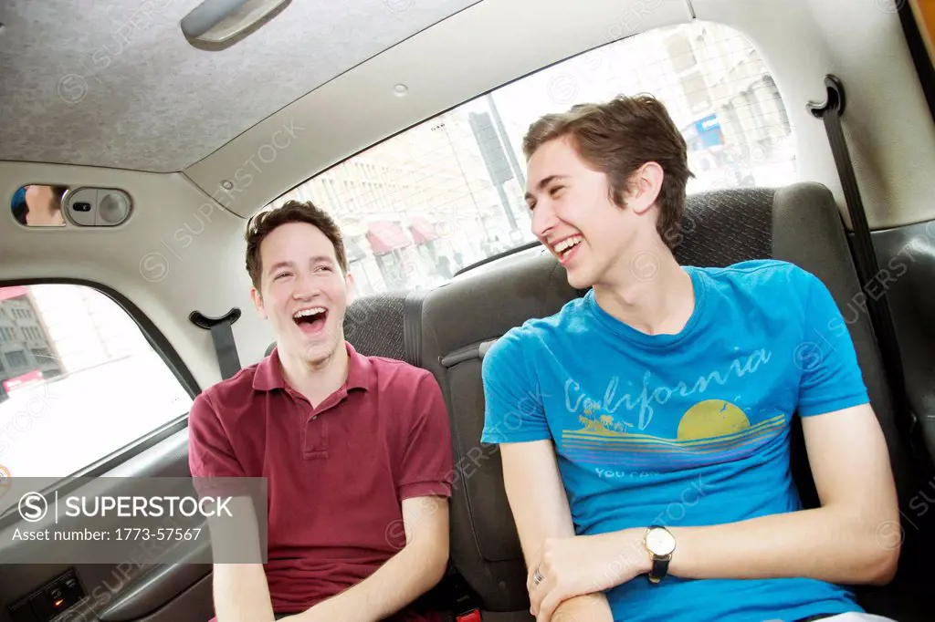 Men laughing in backseat of car