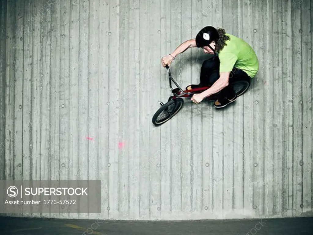 Man doing tricks on bmx bike indoors