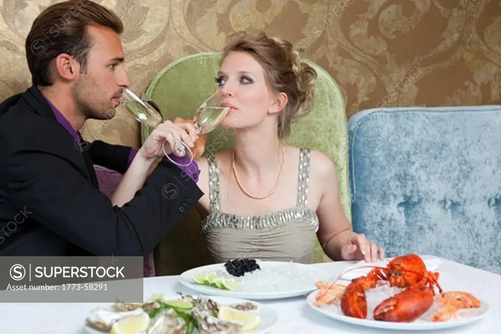 Couple drinking wine with linked arms