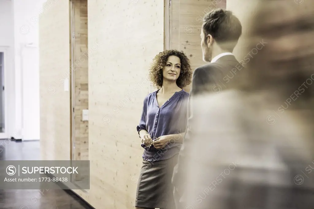 Business people standing in busy hallway