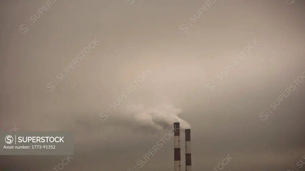 Moscow power station chimneys belches thick smoke into the sky on dark stormy day