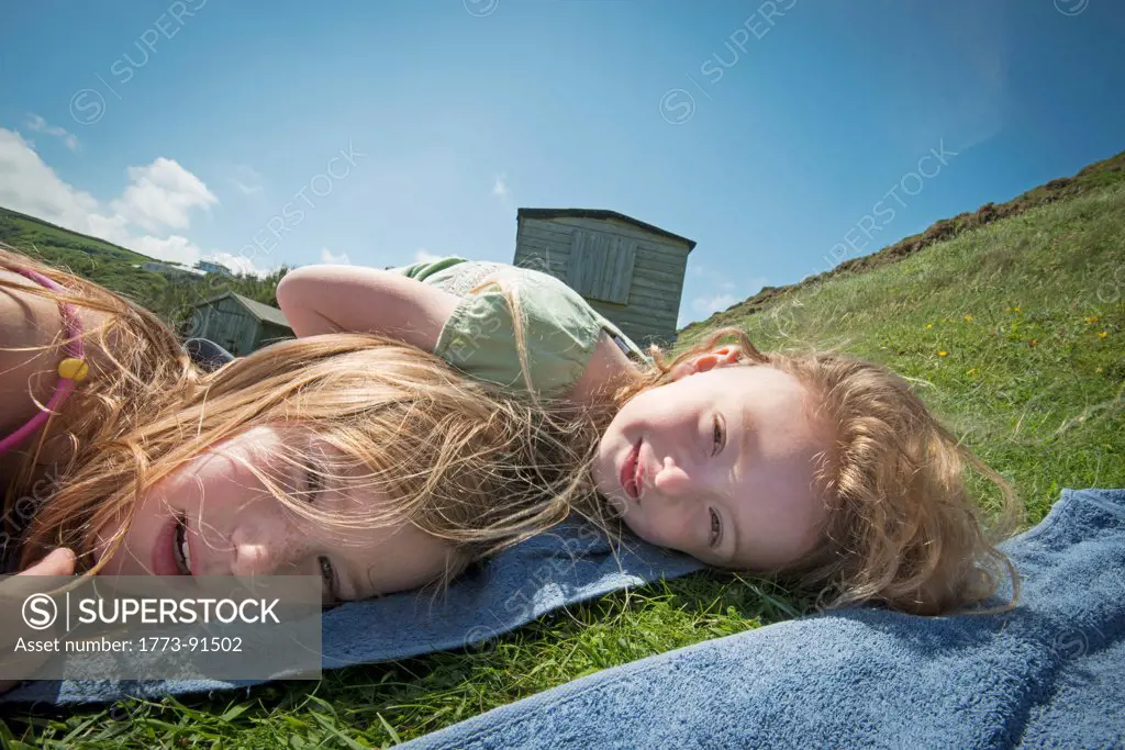 Girls laying on towels in grass