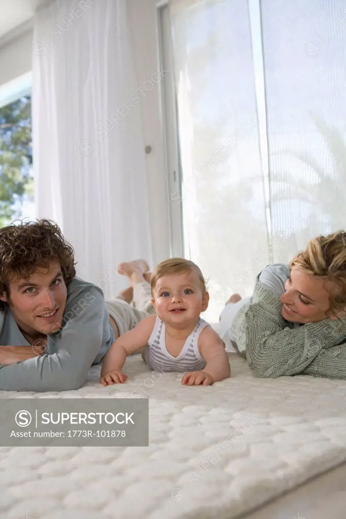 Parents with baby happy on carpet