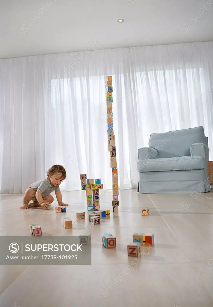 Baby sitting on floor playing with cubes
