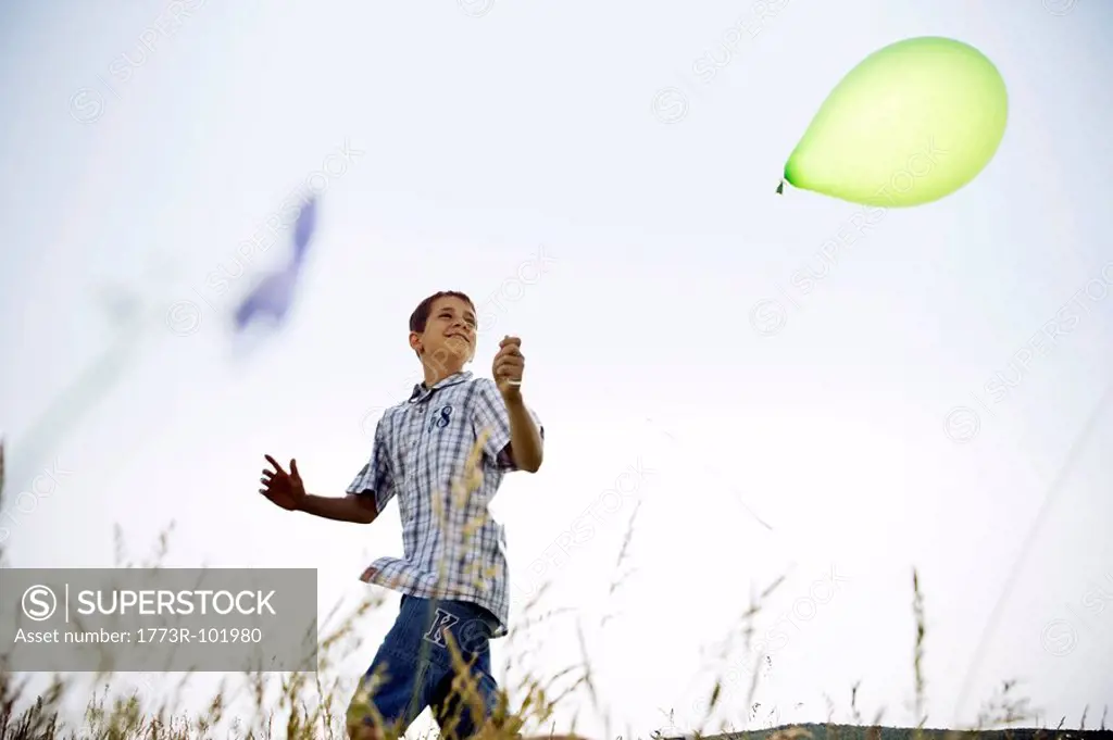 Boy running with balloon