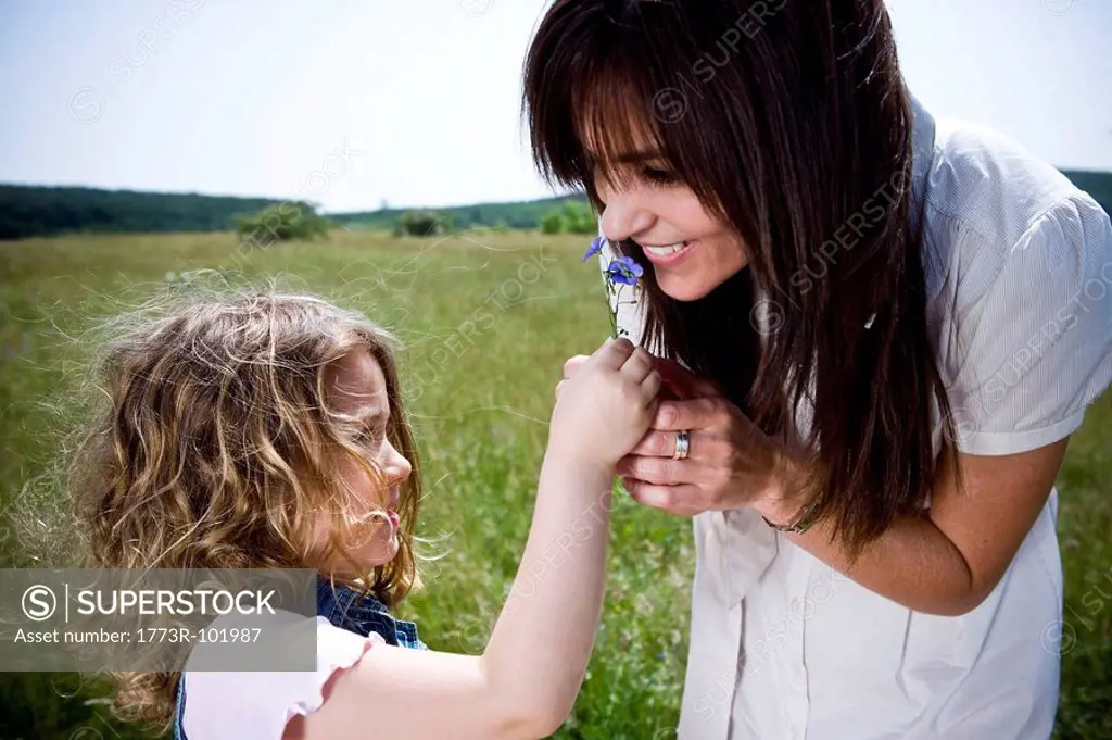 Woman smelling flower with daughter