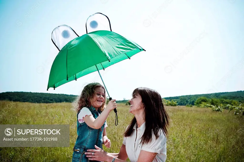 Woman and girl playing with umbrella