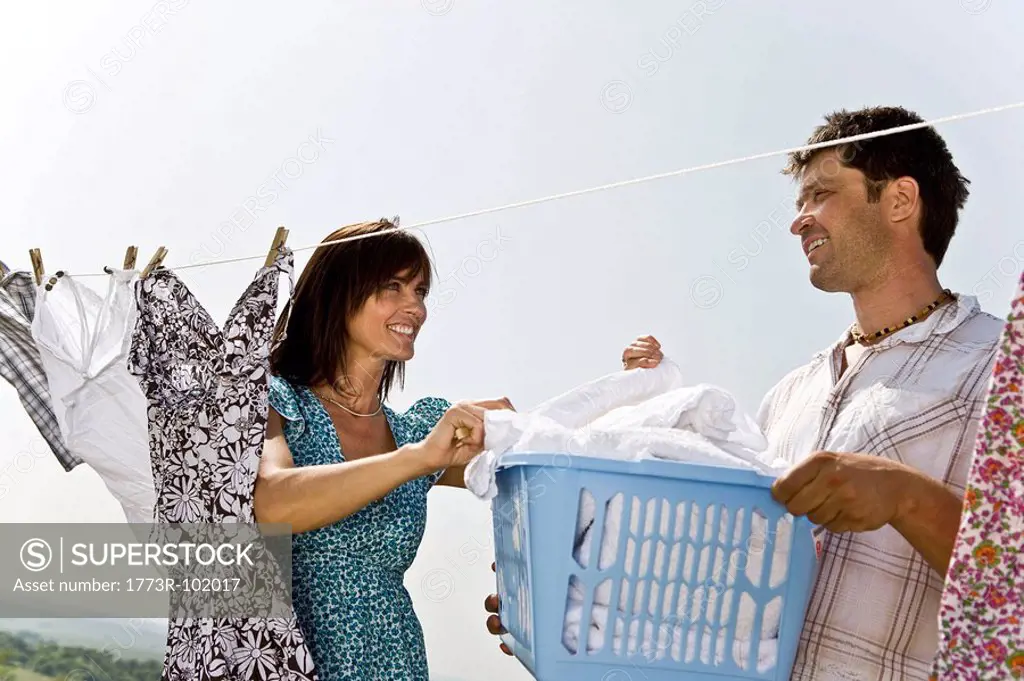 Man helping woman hang clothes