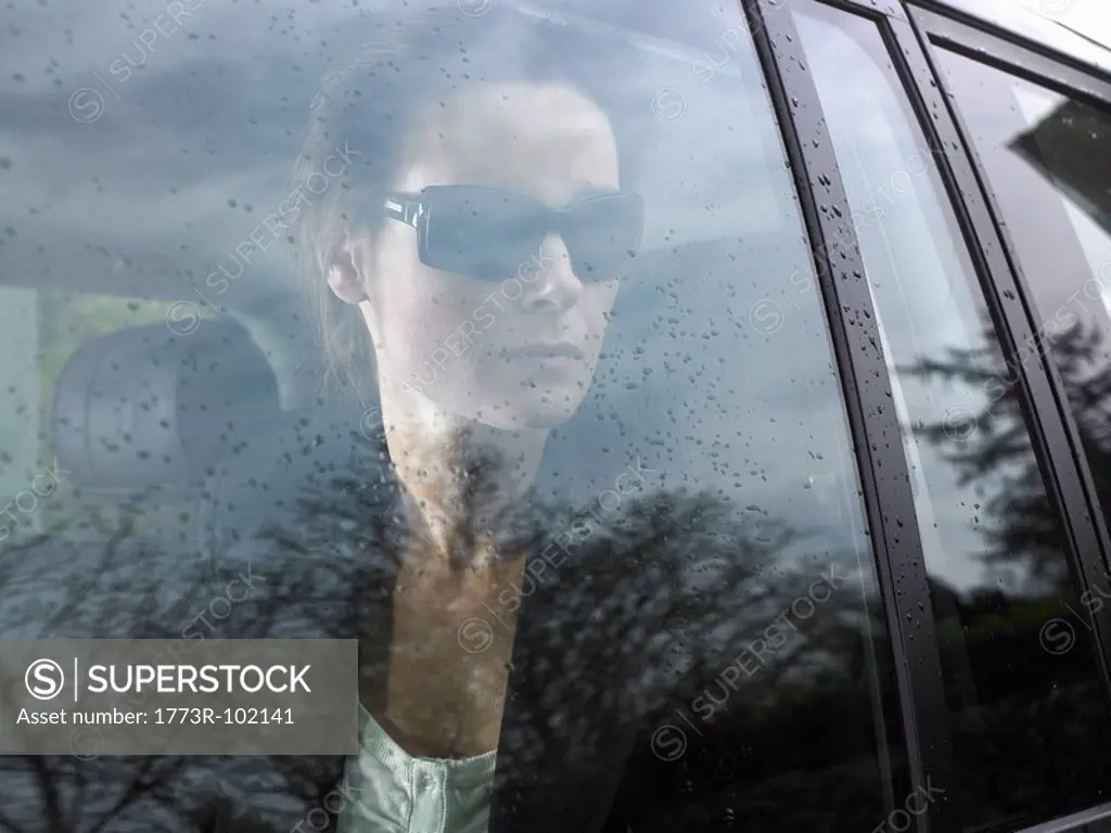 Woman looking through her car window