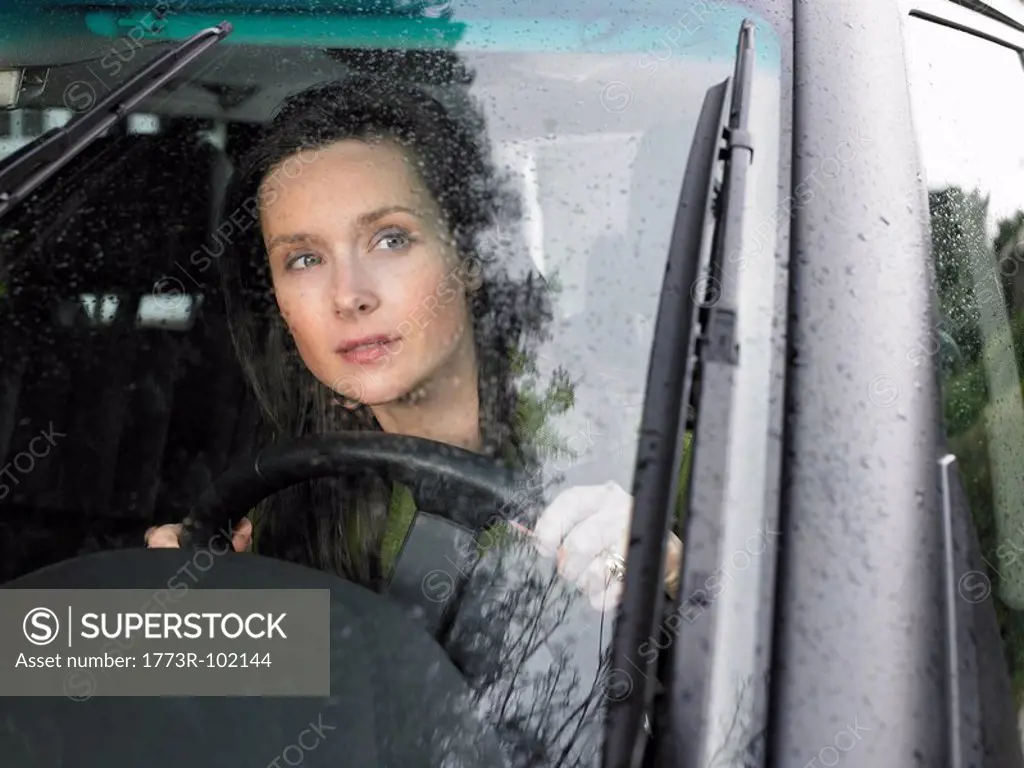Woman driving, rain falling