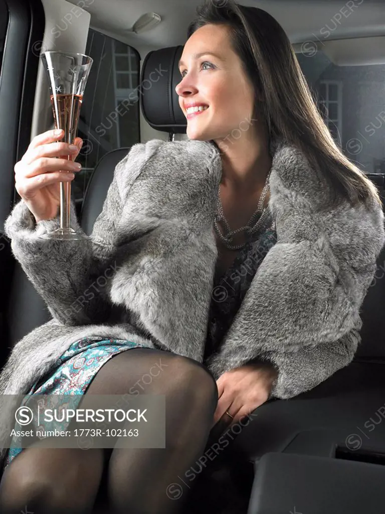 Woman in car, drinking and celebrating