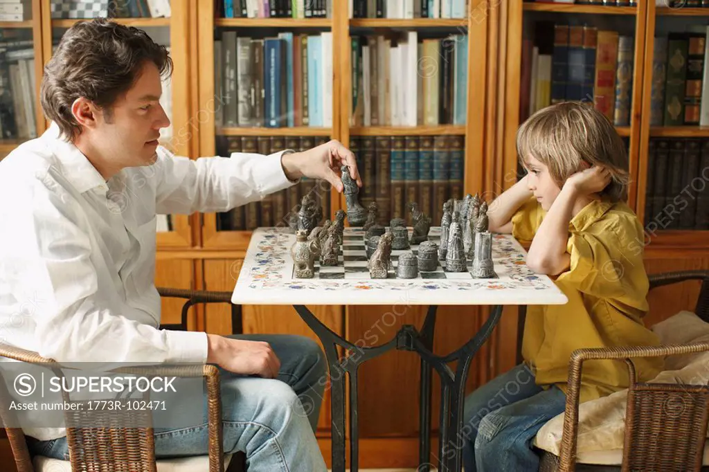 Father playing chess with young boy